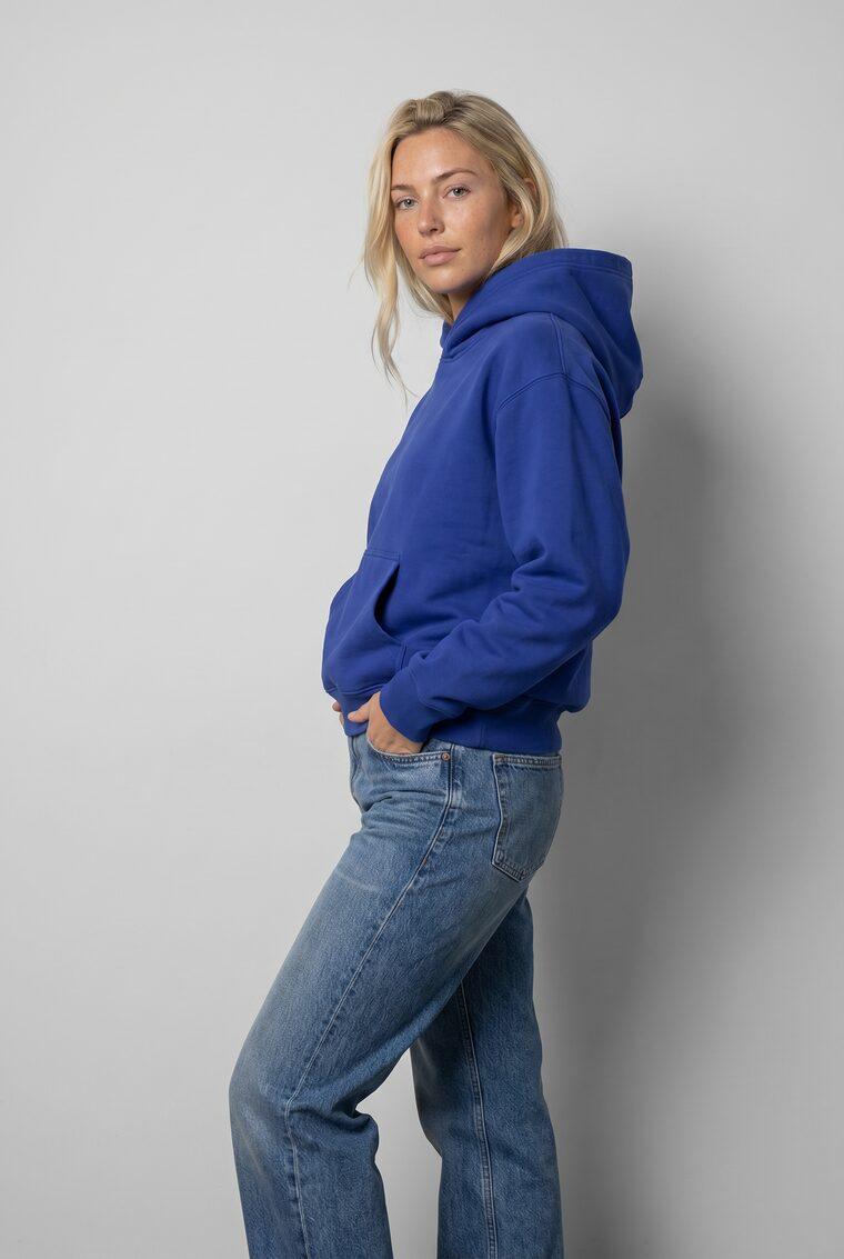 Generated photo of the model wearing the cobalt hoodie with the relaxed jeans