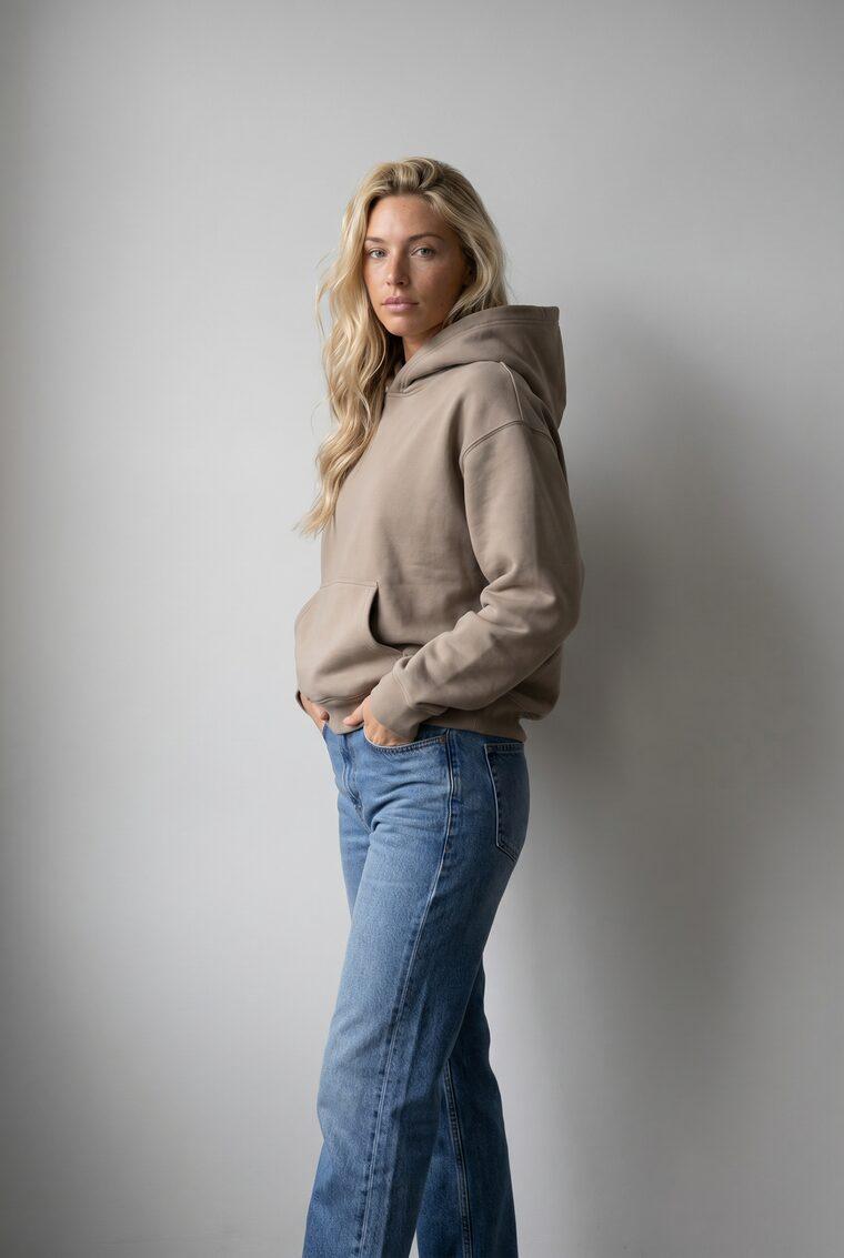 Generated photo of the model wearing the taupe hoodie with the relaxed jeans